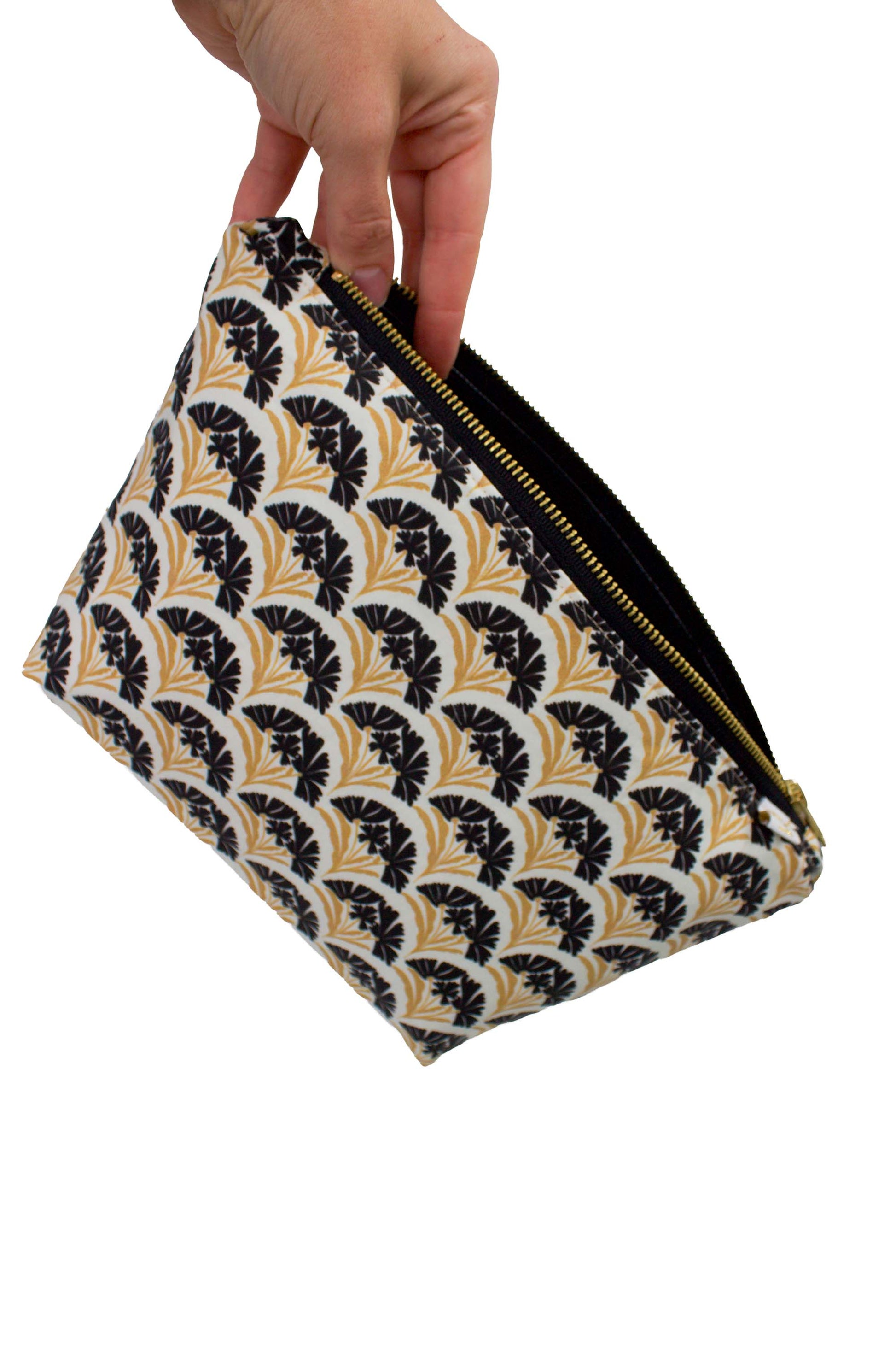 Hand opening the Art Deco Scallop Classic Maxx toiletry bag to show its roomy black wipeable interior and wide zippered opening