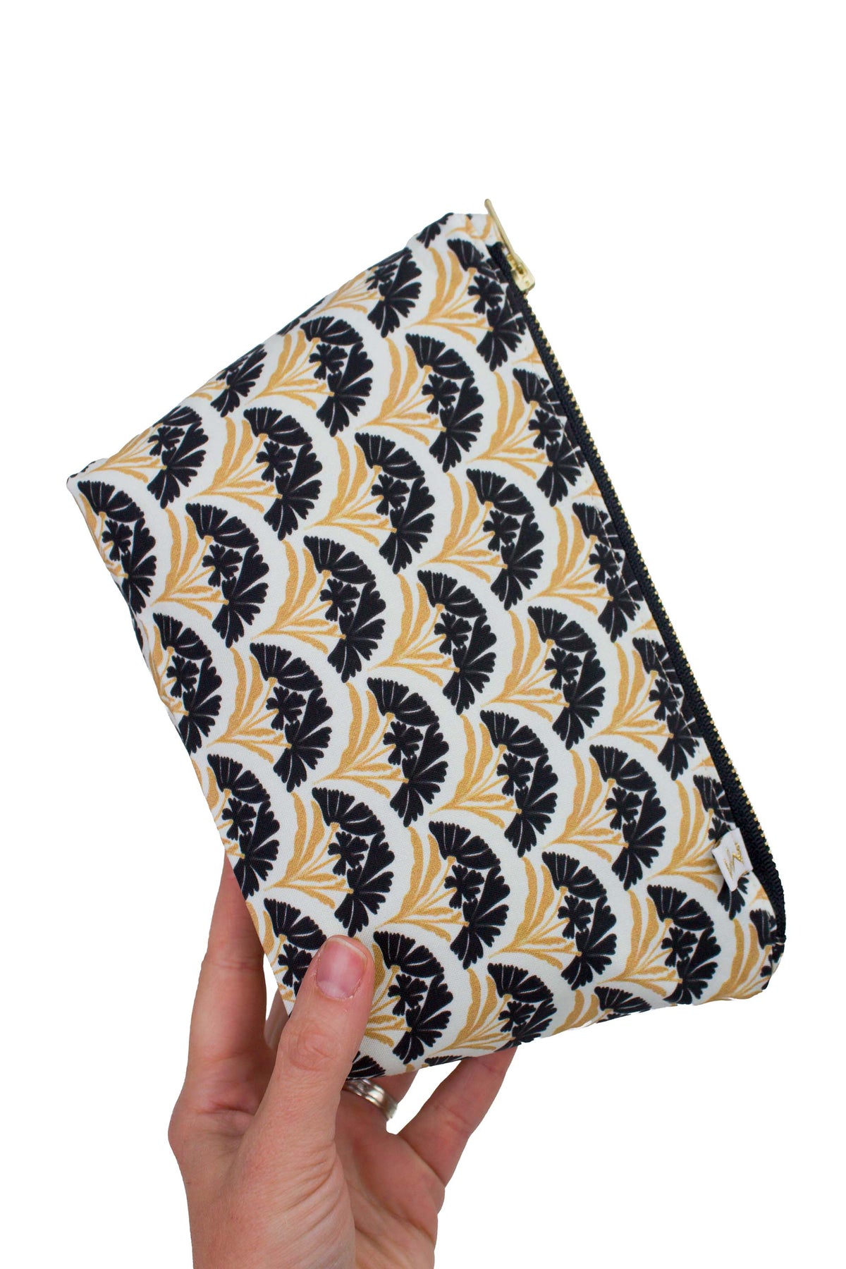 Hand holding the Art Deco Scallop Classic Mini Maxx bag to show its size, structured shape and black and gold floral design.